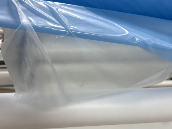 Clear hot-melt adhesive film texture on blue fabric substrate