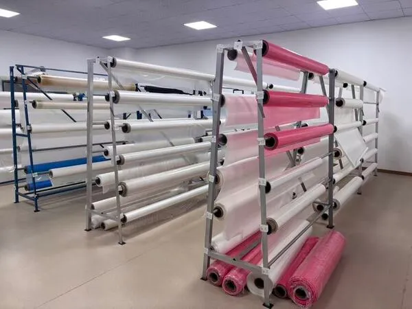 Racks of various hot-melt adhesive film rolls stored in a factory warehouse