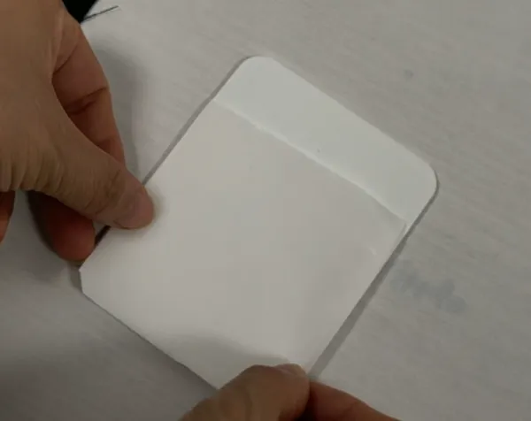 Aligning the adhesive film with the fabric before heat press lamination.