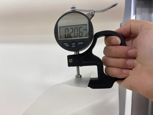Digital caliper measuring exact TPU hot melt adhesive film thickness in millimeters