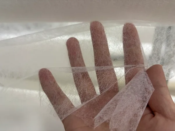 Close-up of open structure PES hot melt adhesive web